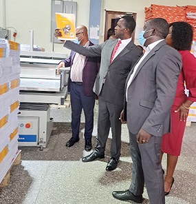 Dr Yaw Osei Adutwum, Education Minister, observing one of the books during the visit to Appointed Time Printers Ltd