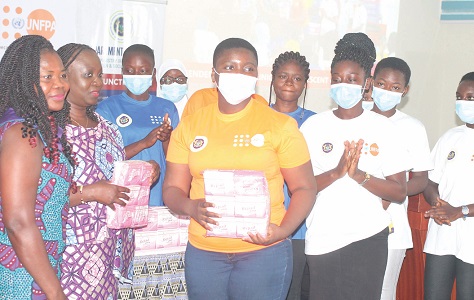 Faustina Acheampong (2nd from left), Director, Department for Gender, Ministry of Gender, Children and Social Protection, presenting sanitary pads to some adolescent girls during the National Gender Equality Clinic for Adolescent Boys and Girls. With them is Selina Owusu (left), Gender Analyst, United Nations Population Fund. Picture: MAXWELL OCLOO