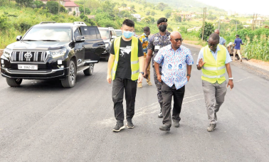 Dr Letsa (middle), flanked by Edward Annan (right) and Wang Hubiao, as they inspect a portion of the road 