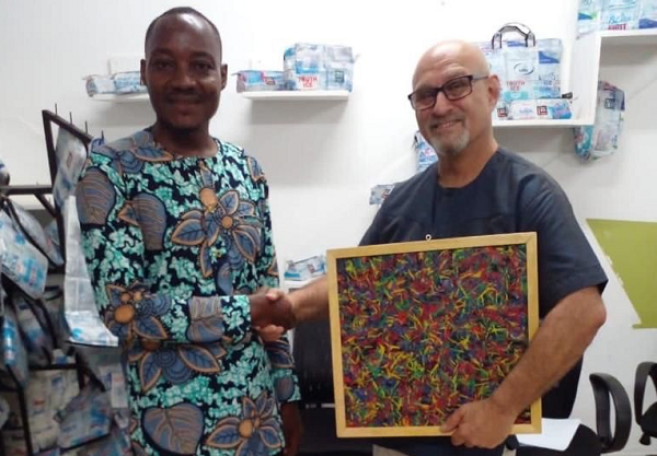The Factory Manager of the company, Mr Elvis Aboluah (left) presenting a recycled artwork to Mr Stuart Gold