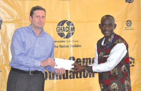  Stefano Gallini (left), the Managing Director of Ghacem, handing over a cement allocation chit to the representative of a beneficiary institution