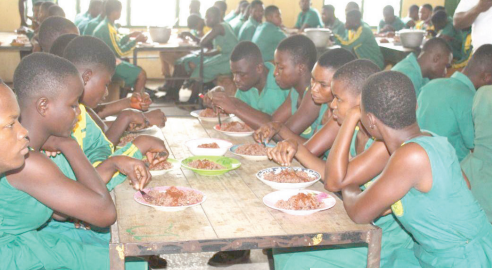 Students at the Jema Senior High School enjoying their lunch during the visit of some members of PIAC to the school last Wednesday