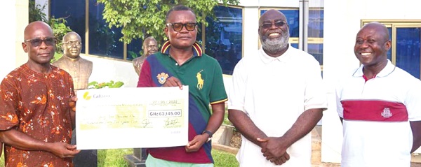 Ernest Boateng Wiafe (3rd from right), a member of the UPSA Global Alumni, presenting the cheque to Kingsley Asare (left). With them are other members of the association