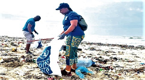 Dr Angela Lusigi (right), the Resident Representative of UNDP in Ghana, collecting plastic waste during the beach clean-up   