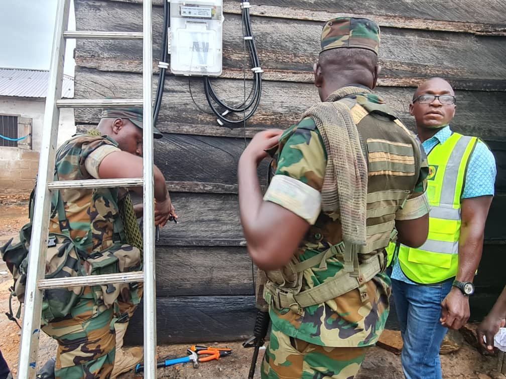A team of military and ECG electrical engineers fixing a prepaid meter