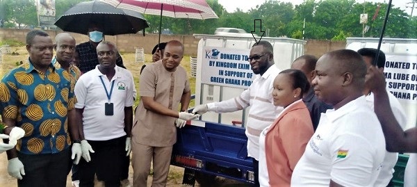  Peter Mensah (arrowed), Corporate Affairs Manager of the Kingdom Exim Group, handing over the tricycle fitted with a water tank for watering and monitoring of the Green Ghana Project trees planted in Tema, to Yohane Amarh Ashitey, MCE, Tema. Picture: BENJAMIN XORNAM GLOVER