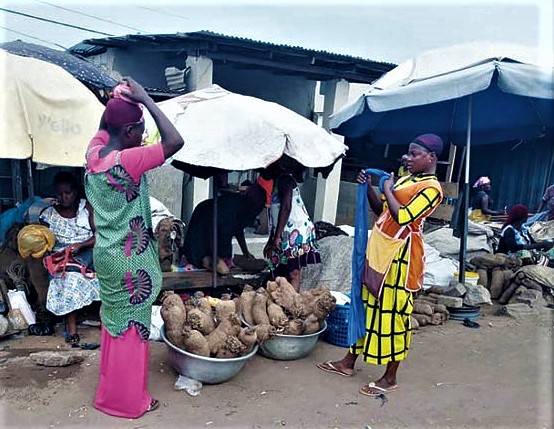 38-year-old Bintu (right) preparing a head pad to carry a fully loaded head pan of yams 38-year-old Bintu (right) preparing a head pad to carry a fully loaded head pan of yams