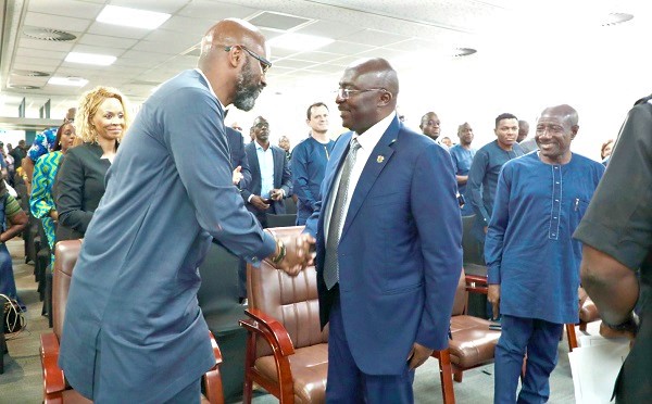 Dr Mahamudu Bawumia in a handshake with Ralph Mupita, President and CEO of MTN Group. Looking on is Ebenezer Asante