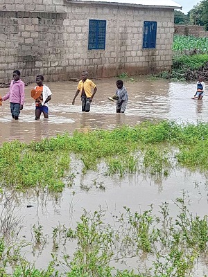Some schoolchildren wading through the flood water