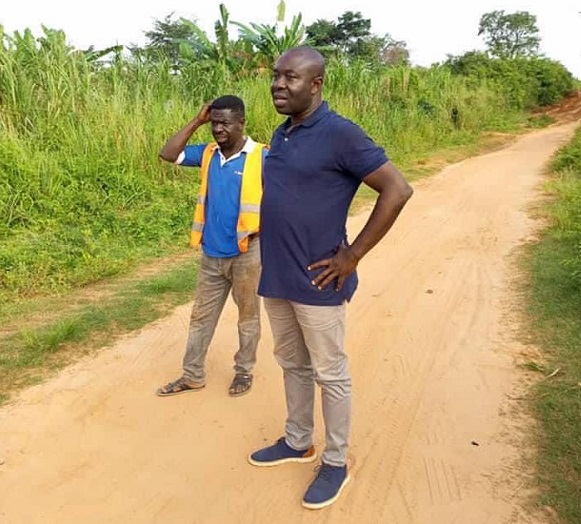 Emmanuel Kwadwo Agyekum (right), Member of Parliament for Nkoranza South, looking at the extent of work done on the feeder road