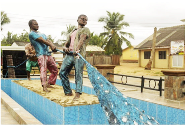 Sculptured  fishermen drawing a seine net at the Akosua Village