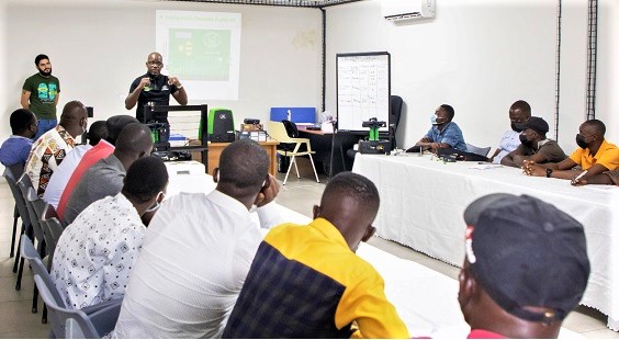 Mr Yves Djuma (standing right) addressing the youth trainees at the workshop