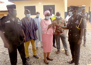 ACP Mr F. S. Adikah (right) receiving the keys to the Police Station from Victoria Adu. Others in the picture include Chief Supt. Daniel Amoako (left) and Haruna Amadu (second from left), the Municipal Coordinating Director for Birim Central.