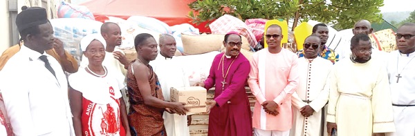 Rt. Rev. Alexander Asmah (5th from right), the Bishop of the Sekondi Diocese, Anglican Church, presenting the items to Nana Kwame Asamoah (4th from left), Tufuhen of the Bepoh Traditional Area, while members of the church and the community look on