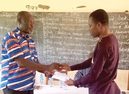 Torney Eglu (left) presenting the cheque to David Yao Vorsah, the headteacher of Adrume M.A.  Primary School