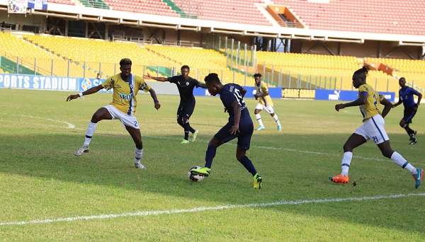 Accra Lions' Basit Seidu tries to dribble past Solomon Adomako of Accra Lions