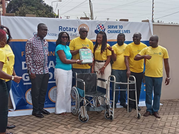 The President of the Rotary Club of Accra-Airport East, Mr Kwabena Barning presenting one of the items to the Executive Director of the Foundation, Madam Vivienne Gadzekpo Duker with other members of the club looking on