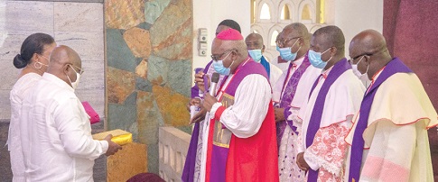 Rt Rev. Dr Victor Attah-Boafo, the Diocesan Bishop of the Cape Coast Cathedral, praying for President Akufo-Addo and Mrs Rebecca Akufo-Addo(left), the First Lady, while other members of the clergy look on after the presentation