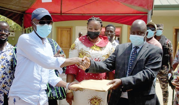 Mr Stephen Yakubu (right), the Upper East Regional Minister, handing over the contract documents to Mr Jawad Abdul-Rakeeb (left), the contractor, while Ms Rita Atanga (middle), DCE for Bongo, looks on