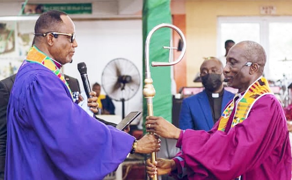 Bishop S. N. Mensah (left), outgoing President of the FGCI, handing over the staff of leadership to new President, Rt Rev. Godwin Dela Fiagome, at the induction ceremony
