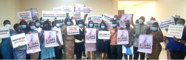 Female staff of the ECG holding placards with various inscriptions as part of activities to mark International Women’s Day