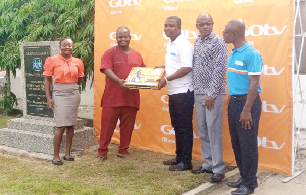 Alex Okyere (2nd from left), Managing Director of MultiChoice Ghana, presenting a decoder to Alex Duodu, Alternative Care Coordinator of the SOS Children's Village, Tema