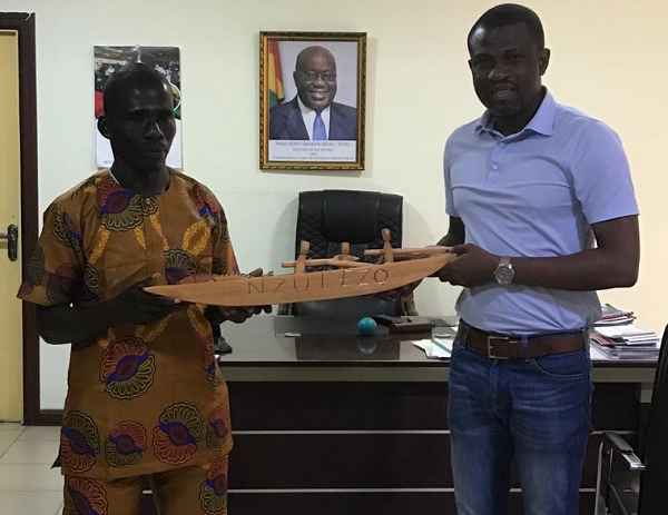 The Deputy Minister of Tourism, Arts and Culture Mr. Mark Okraku- Mantey receiving the gift from Mr. Francis Addy, a native of Nzulezu and his team to address their concerns at his office on Friday, March 18,2022.