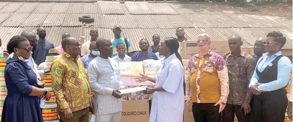 Dakoa Newman (4th from left) presenting the items to Mr Stephen Abamfo (3rd from left). With them are some constituency executive of the NPP and some officials of the Okaikoi South education office