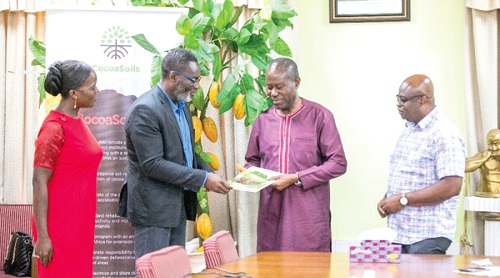 Dr Richard Asare (2nd from left), Coordinator, CocoaSoils Global Programme, presenting the handbook to Joseph Boahen Aidoo (2nd from right), CEO, COCOBOD