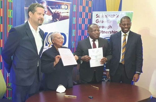 Ekow Afedzie (2nd from right) and Dr Marlene Street Forrest (2nd from left) displaying the MoU after the signing. With them is Rev. Daniel Ogbarmey Tetteh (right)