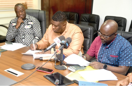 Akwasi Agyeman (right), Chief Executive Officer, Ghana Tourism Authority, and Abdul Karim Abdullah (middle), Chief Executive Officer of Afrochella, signing the MoU  while Dr Ibrahim Mohammed Awal, Minister of Tourism, Arts and Culture, looks on