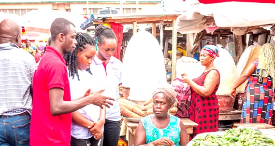 Some students interacting with a trader in yam