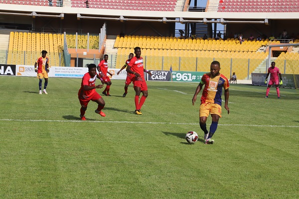Heart's Gladson Awako controls the ball as his marker closes in on him