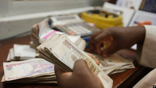 FILE - a money changer counts Nigerian naira currency at a bureau de change in Lagos, Nigeria, Oct. 20, 2015.