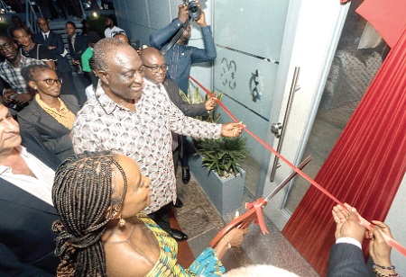 Abena Osei-Asare (right) being assisted by Alan Kyerematen to cut the tape to inaugurate the office infrastructure