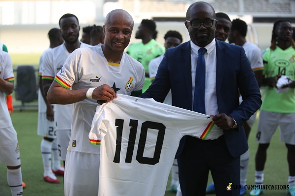 Andre Ayew receiving a jersey from Kurt Okraku