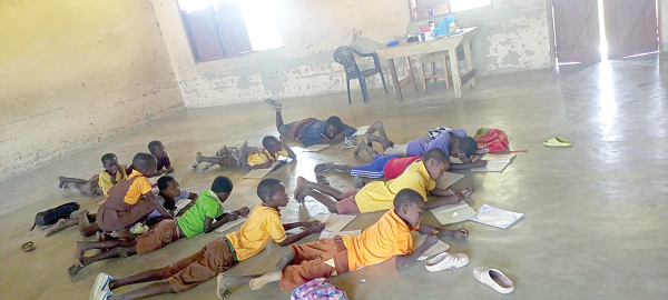 Primary three pupils of Beo Tankoo primary school lying on the floor to take part in a lesson