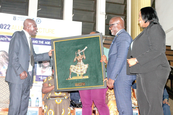 Nana Dwemoh Benneh (2nd from right), CEO, Universal Merchant Bank (UMB), presenting an art piece to Daniel Kufuor Osei (left), former diplomat, at the University of Ghana 2022 alumni lecture. PICTURE: MAXWELL OCLOO