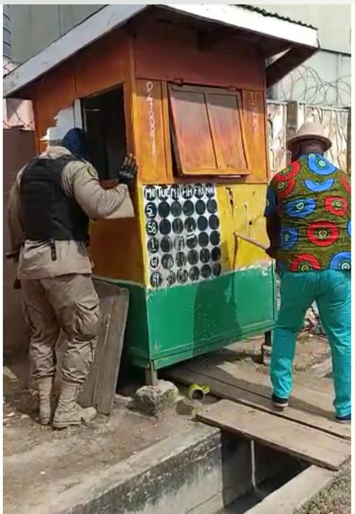 The security operatives destroying a lotto kiosk