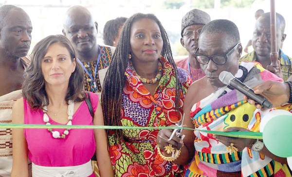 Nana Ampofoh Kyei-Baffour II (right), the Asemhene, cutting the tape to officially launch the 2022 GrEEn Fair in Kumasi. Looking on are Gloria Bortele Noi (middle), Director of Policy Planning Monitoring & Evaluation, Ministry of Employment and Labour Relations, and Marta Brignone, Programme Manager of Green Project at the European Union in Ghana
