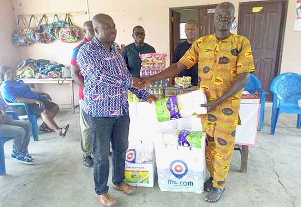 Selorm Adzorze (left), the Volta Regional Chairman of UNICOF, presenting the items to Nelson Atito, the Manager of the Lepers village
