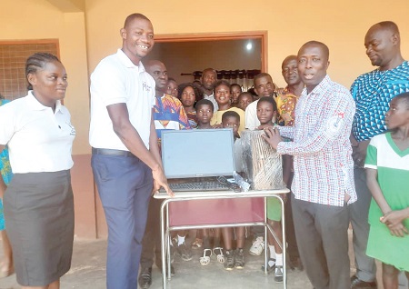 Owusu Banahene (3rd from right), Headmaster of Feyiase Roman Catholic Primary School, receiving the items from Enoch Sunday Tiavor, Assistant Managing Director of the foundation