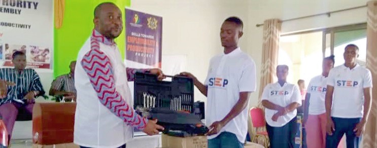 Pius Hadzide (left) presenting a start-up kit to one of the beneficiaries