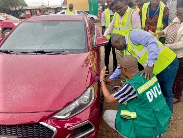 Amos Abakah (squatting), Ashanti Regional Manager, DVLA, using a Tyre Tread Depth Gauge on a vehicle during the demonstration exercise in Kumasi. With him is Richard Kwasi Eyiah, the Compliance and Enforcement Manger. Picture: EMMANUEL BAAH