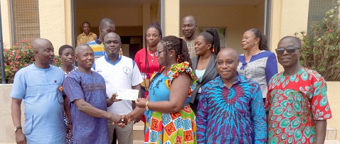 Benedicta Addo-Danquah (3rd from right) presenting the cheque to Evans Boafo, the Headmaster of ODASCO. With them are Augustus Anim Attafuah (2nd from right) and Paul Asiedu (right), a board member of the bank. Behind them are other board members of the bank. 