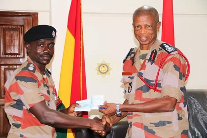 Chief Fire Officer Julius A. Kuunour presenting a cheque to one of the beneficiaries 