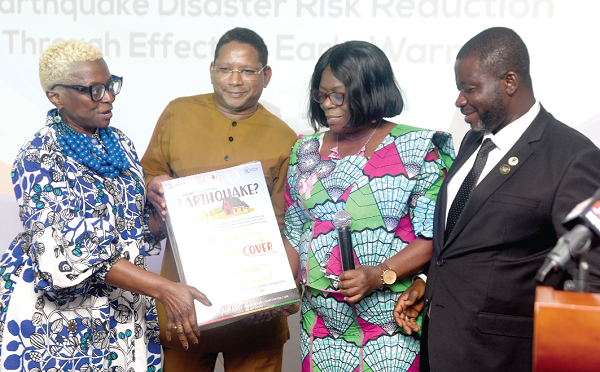 Abdourahamane Diallo (2nd from left), Head of Office and Representative of UNESCO to Ghana, and Babara Tulu Clemens (left), Representative and Country Director of WFP, Ghana, presenting some educational materials on earthquakes to Adelaide Anno-Kumi, Chief Director, Ministry of the Interior, while Eric Nana Agyemang-Prempeh (right), Director-General of NADMO, looks on. Picture: EMMANUEL QUAYE   