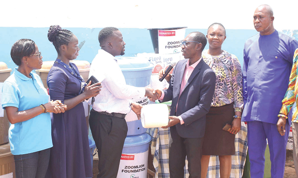Kwame Boakye Appiah-Nuamah (3rd from left), Programmes Assistant Officer, Zoomlion Foundation, presenting the items to Kean Adjei Appiah (4th from left), Director of Education, La Nkwantanang-Madina Municipality. With them are Rebecca Tuffour Peprah (2nd from left), Project Officer, Zoomlion Foundation, and Anto Ofosu Essel (right), Headmaster, Ayi-Mensah Basic School. Picture: Maxwell Ocloo