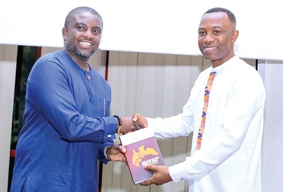 Anane Agyei, the author, presenting a copy of the book to Dr Kwabena Bempah Tandoh (left), Deputy Director-General in charge of Quality and Access, Ghana Education Service, at the launch in Accra
