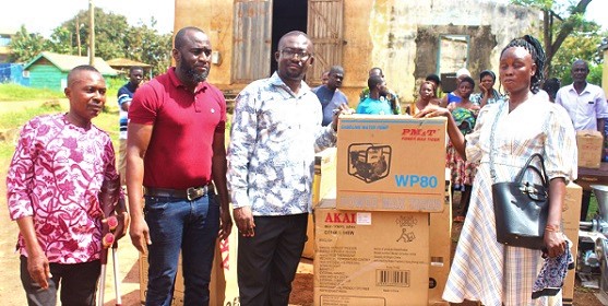 Alexander Obour Damoah (3rd from left), Wenchi Municipal Chief Executive, presenting a water pumping machine to a beneficiary